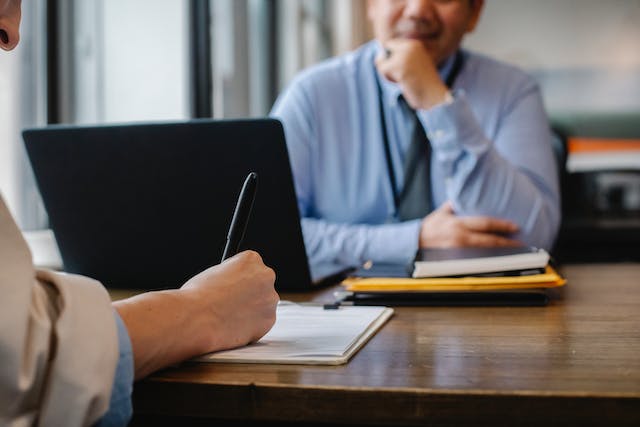 tenant signing a leasing agreement as a property manager oversees